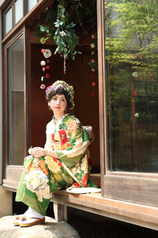 A bride wearing a green and gold hikifurisode