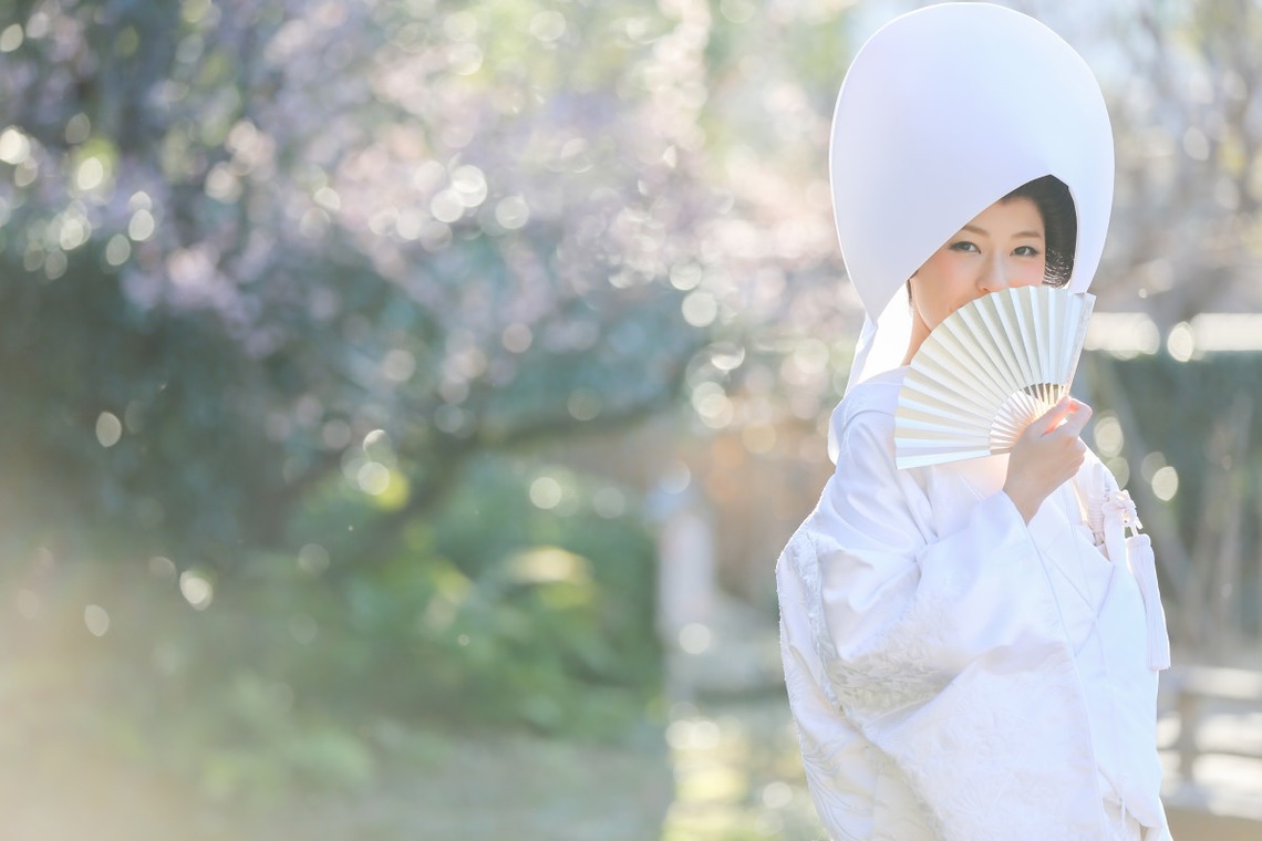 Lady wearing a shiromuku with an open hand fan