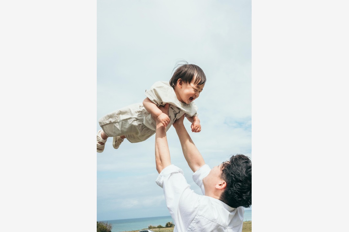 ポートレート沖縄が出張撮影した家族写真(キッズ,ベビーフォト)などが写った「自然の中の家族の自然な姿＠読谷村の海岸と芝生」の家族写真