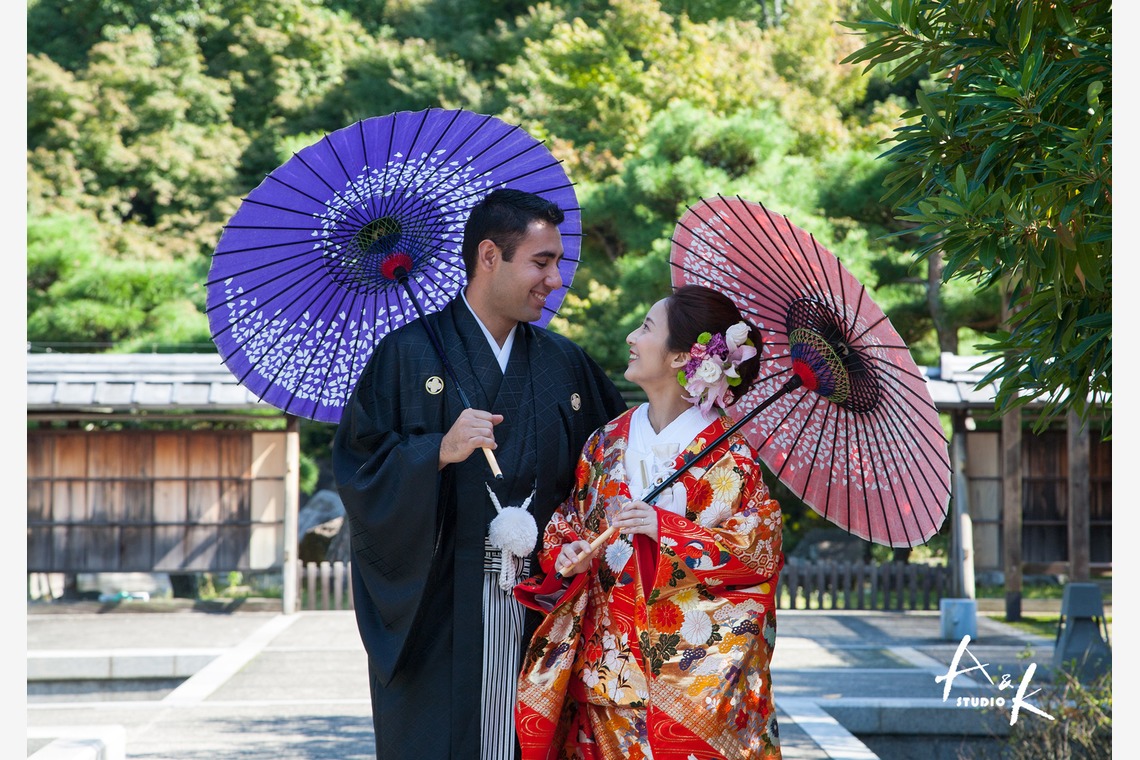 Kimono-dressed couple at a wooden Japanese gate.