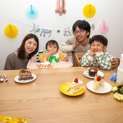 岩坪眞一郎が出張撮影した慰め, 食器, ソファーなどが写った「一歳の誕生日記念」の家族写真