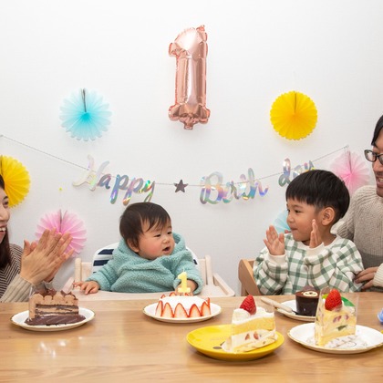 岩坪眞一郎が出張撮影した慰め, 食器, ソファーなどが写った「一歳の誕生日記念」の家族写真