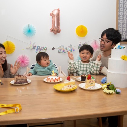 岩坪眞一郎が出張撮影した慰め, 食器, ソファーなどが写った「一歳の誕生日記念」の家族写真