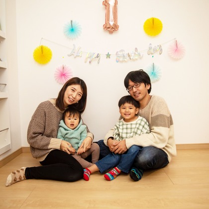 岩坪眞一郎が出張撮影した慰め, 食器, ソファーなどが写った「一歳の誕生日記念」の家族写真