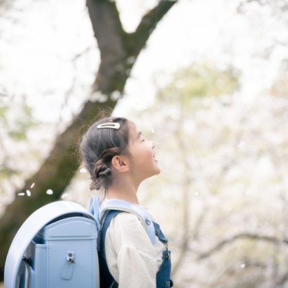 戸澤麻衣が出張撮影した荷物とバッグ, 植物, グラウンドカバーなどが写った「昭和記念公園で新一年生の撮影」の家族写真